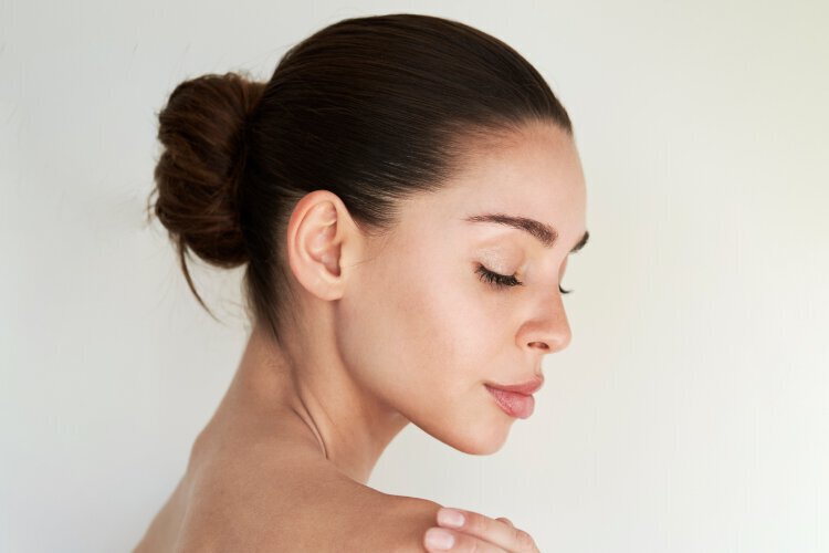 Non-Surgical cosmetic procedures feature - Woman with beautiful skin looking over shoulder
