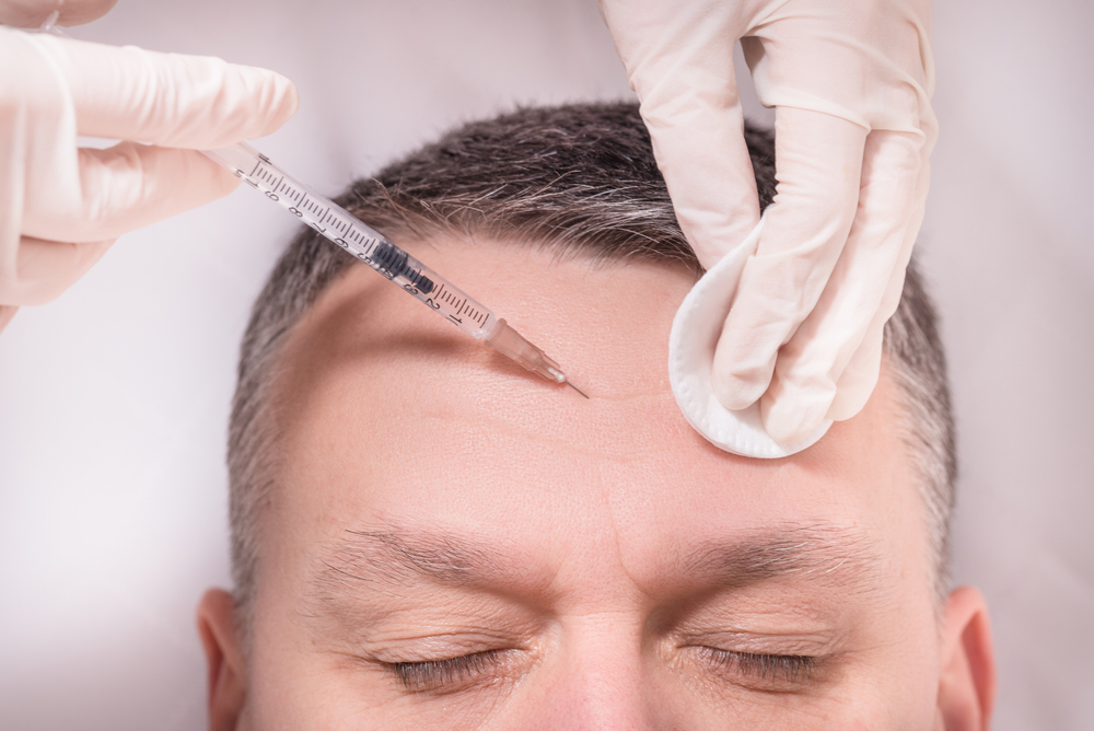 Man receiving botox injection in forehead.